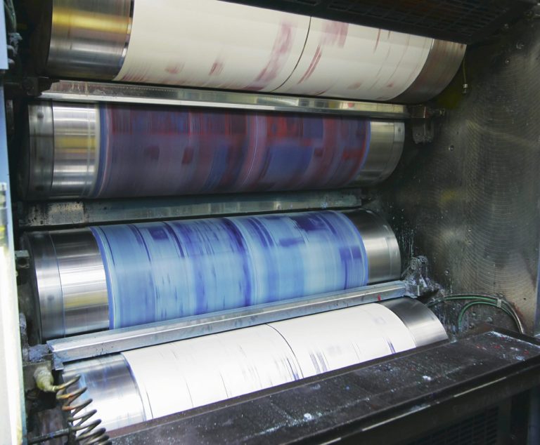 Rodillos de impresión con tinta en diferentes colores, en una prensa gráfica.
